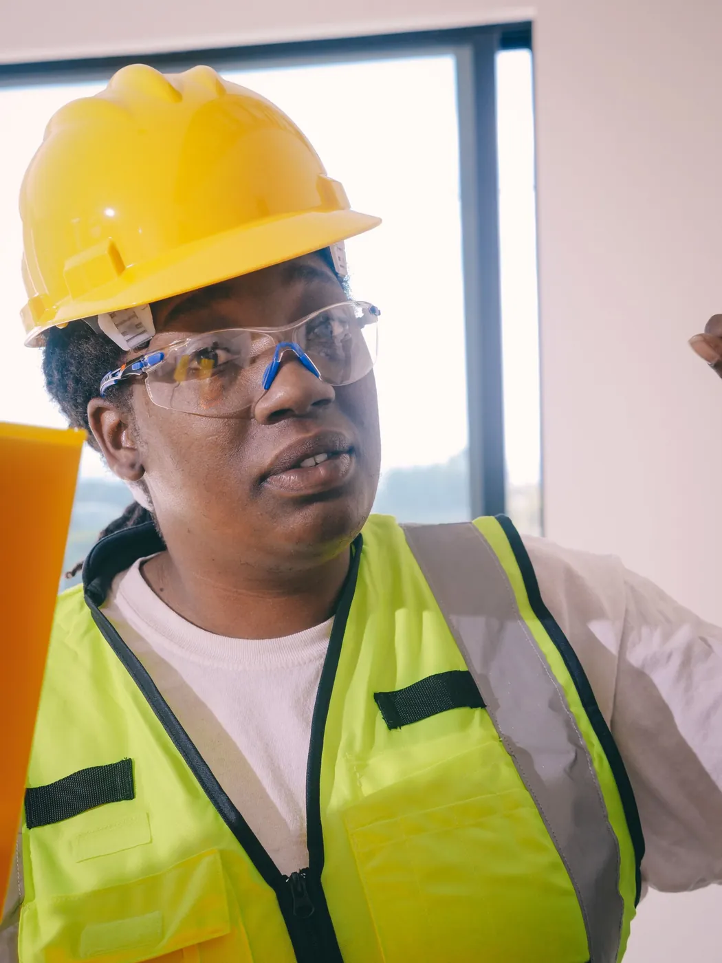 Ingénieure en casque jaune, lunettes de protection et gilet haute visibilité