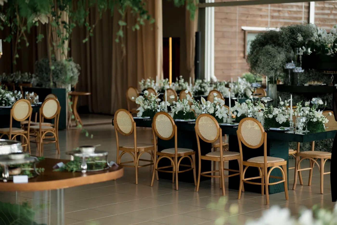 Salle de réception avec longues tables vertes et chaises dorées